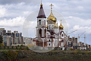 A lonely church with golden domes against a cloudy sky.