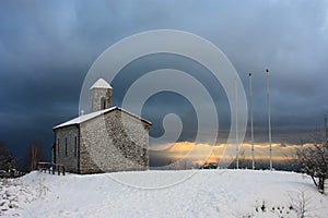 Lonely church in romantic snowy and frozen landscape on top of the mountain in winter