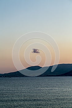 Lonely cloud over an island mountain, sunset