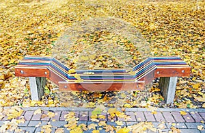 Lonely colorful wooden bench in park in the autumn