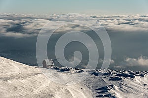 Lonely Cottage high in the Mountain in a snowy Winter Landscape