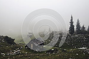 A lonely cottage in the misty and foggy forest just after the storm. Photograph was taken at Corvara in Dolomites mountain range,