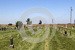 Lonely country cemetery that has just been mowed on the plains with plowed field behind