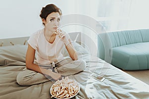 Lonely Crying Woman Eats French Fries On The Bed.