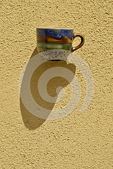 Lonely cup on yellow wall texture