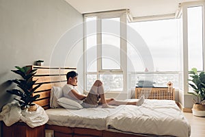 Lonely and depressed man in his bedroom in the apartment.