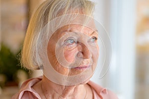 Lonely elderly woman standing reminiscing