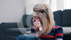 Lonely elderly woman wiping tears with tissue. Loneliness at old age
