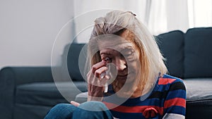 Lonely elderly woman wiping tears with tissue. Loneliness at old age