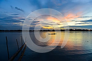 Lonely fisherman in canoe on Sepik river in Papua New Guinea during dusk