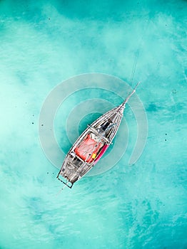 Lonely fishing boat in clean turquoise ocean, aerial photo