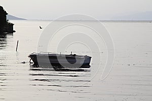 Lonely fishing boat docked in calm lake. wooden fishing boat in a still lake water.