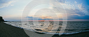 A lonely fishing boat in the sea against the background of the evening sunset sky. Large panorama