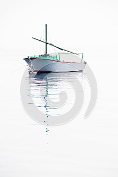 Lonely fishing boat on very calm sea