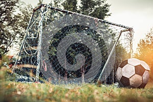 Lonely football gate or soccer goal in neglected on field with f