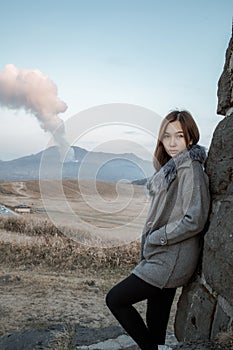 Lonely girl in Area of Aso active volcano background with smoke at Mount Aso