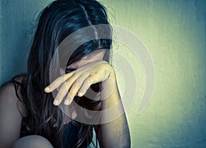 Lonely girl crying with a hand covering her face