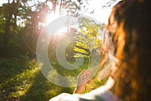 A Lonely girl hold leaves and standing in the forest and sunset