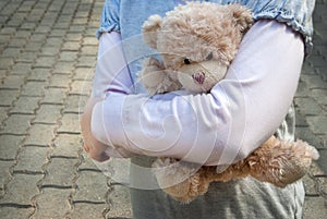 Lonely girl holding a teddy bear as her best friend