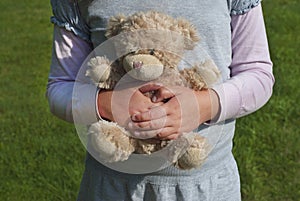 Lonely girl holding a teddy bear as her best friend