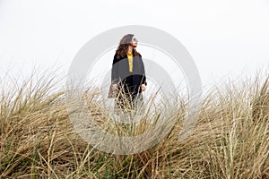 Girl rain sea wind portrait woman spring coat long hair curly mood shore beach dry grass sky