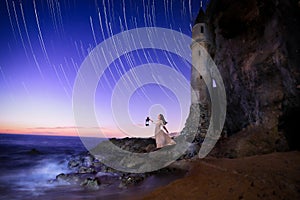 Lonely Girl Looking to the Ocean With a Lantern Seeking