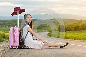 Lonely girl sitting on the road