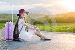 Lonely girl sitting on the road