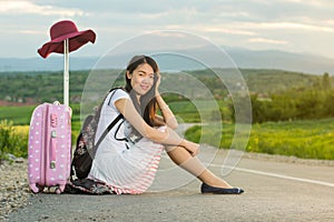 Lonely girl sitting on the road