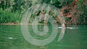 Lonely girl swimming pond green nature. Focused woman resting in amazing lake