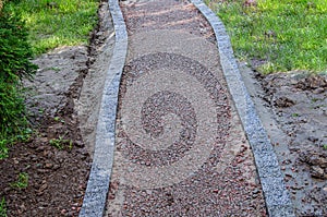 Lonely, gravel macadam footpath with grass on either side