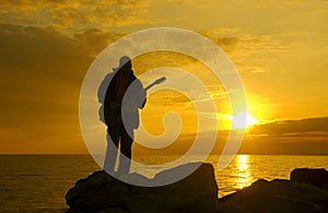 Lonely guitarist, evening coast