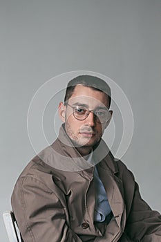 A lonely handsome guy in a raincoat and glasses with different moods