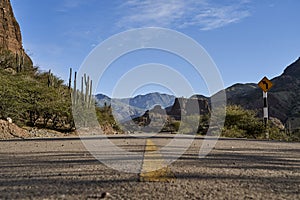 Lonely highway with yellow middle line in a beautiful and arid desert landscape.