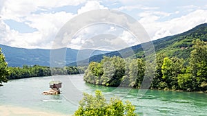 Lonely house on the river Drina in Bajina Basta. Cloudy sky and mountains on background. Serbia