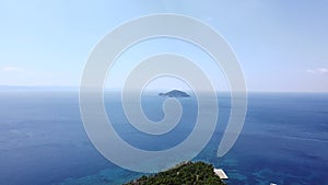 Lonely island in a distance in open sea. Aerial view