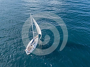 Lonely isolated yacht under the sail with tall mast going in still sea aerial top view ÃÂ¼