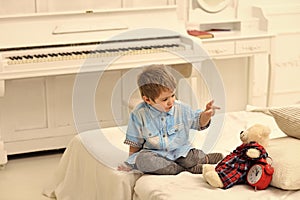 Lonely kid Child in bedroom telling fairytale for toy. Fairytale concept. Boy with favourite toy on bed, wishing sweet