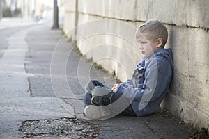 Solitario poco ragazzo si siede sul 