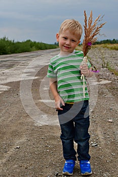 Lonely little boy stands in the field on the landing strip landing strip