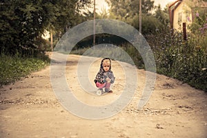 Lonely lost kid girl on rural road in countryside concept carefree childhood in countryside rustic lifestyle