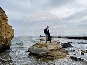 Lonely man at the beach on autumn day