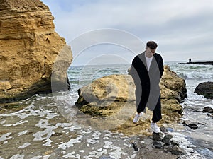 Lonely man at the beach on autumn day