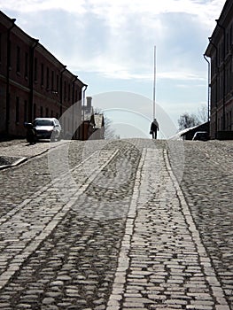 A lonely man in the cobblestone road in suomenlinna