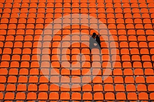 lonely man on the empty stadium seat cheering for the team, one man army concept