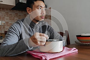 Lonely man having a meal alone in his home.