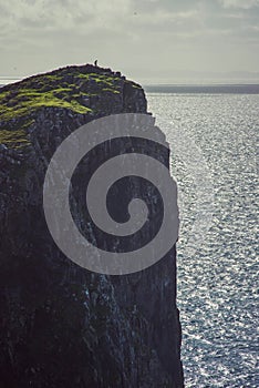 A lonely man in stunning dusk cliff, Scotland, UK