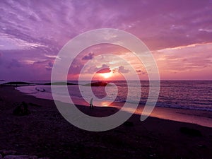 Lonely man waking along the Beach during sunset