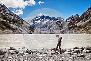 Lonely man walking along the lake of Mount Cook, New Zealand