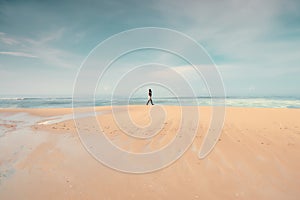 A lonely man walking on the beach.